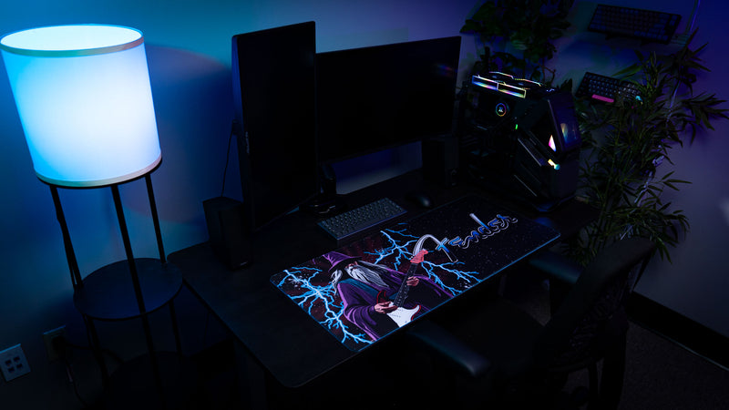 Full-width Fender Electric Spellcaster desk mat showing dramatic purple, blue, and black fantasy artwork