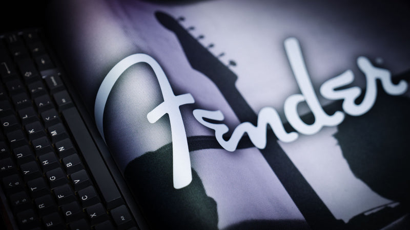 Full-desk view of the Fender Family Night Out 1954 XXL mat beneath a keyboard and mouse
