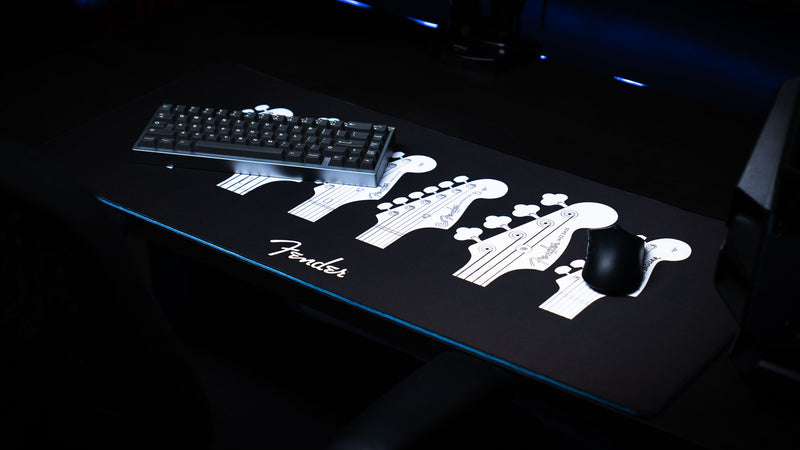 Angled desk view of the Fender Headstocks XXL desk mat and its detailed instrument artwork