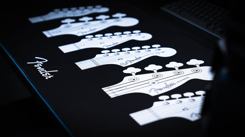 Close view highlighting the white Fender headstock linework printed on the black desk mat