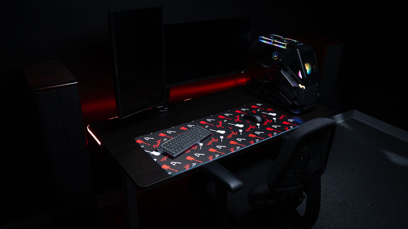 Wide desk view of the Fender Repeat mat and its red-and-black artwork spanning a desktop workspace