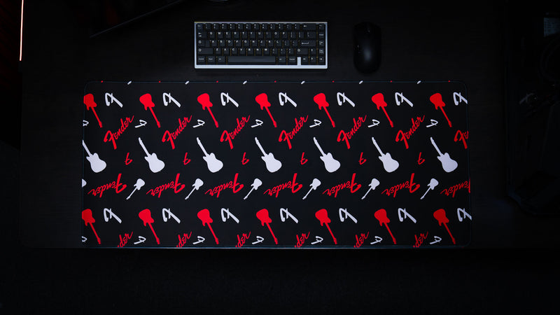 Angled desk view of the Fender Repeat desk mat and bold monochrome-red palette