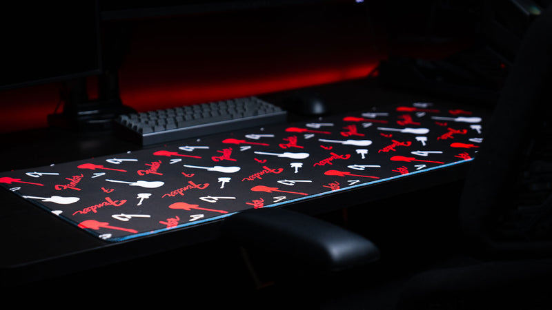 Detailed view of the Fender Repeat desk mat with red logos and guitar silhouettes on black