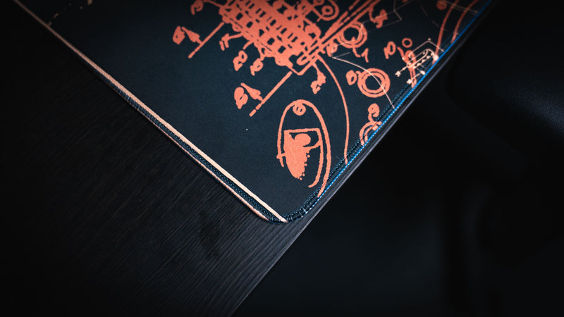 Full-desk view of the gold Fender Stratocaster Blueprint XXL mat beneath a keyboard and mouse