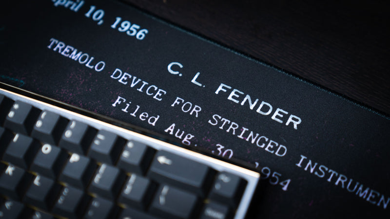 Angled view of the purple Fender Stratocaster Blueprint XXL desk mat and cyan patent-style linework