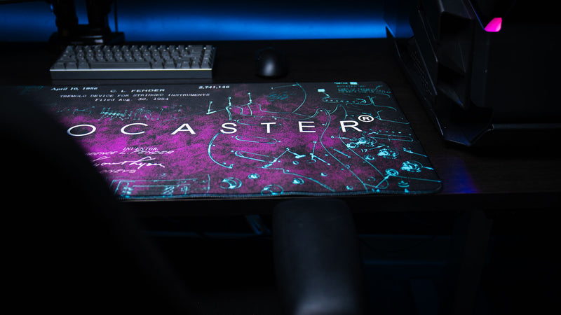 Close view highlighting cyan Stratocaster hardware callouts on the deep purple desk mat