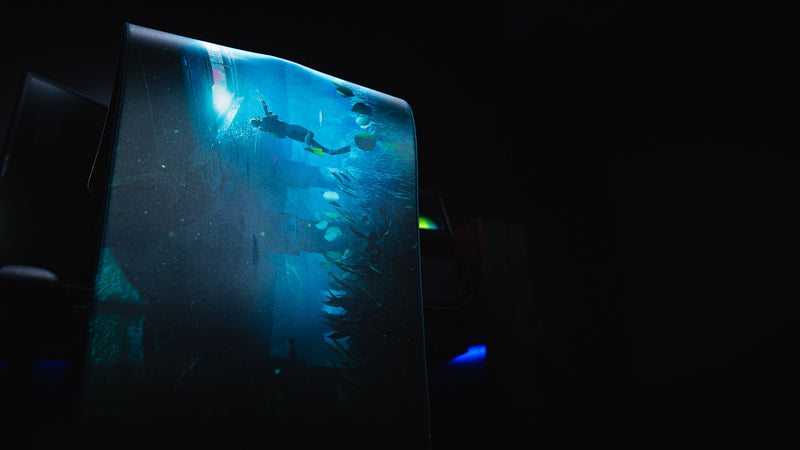Official Rust Labs Breach deskmat standing upright to showcase its flexible construction, premium stitched edges, and immersive underwater Rust artwork.