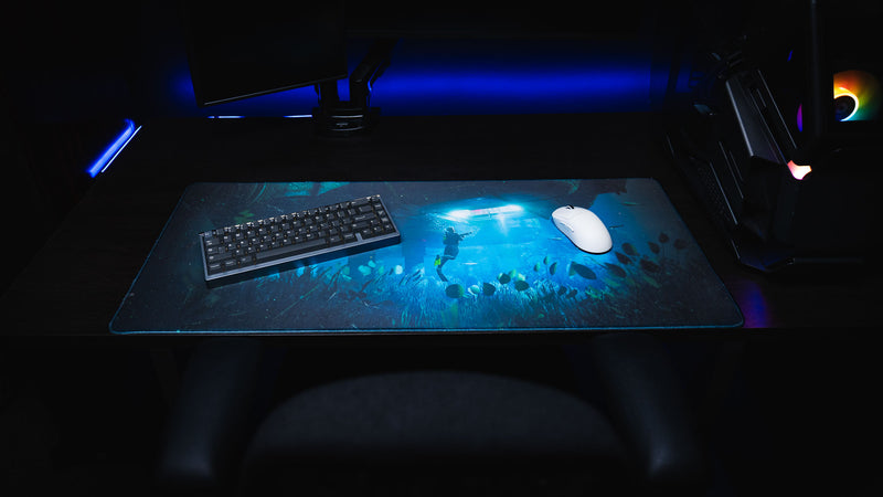 Official Rust Labs Breach premium gaming deskmat featuring an underwater diver beneath the Labs monument, displayed with a mechanical keyboard and gaming mouse.