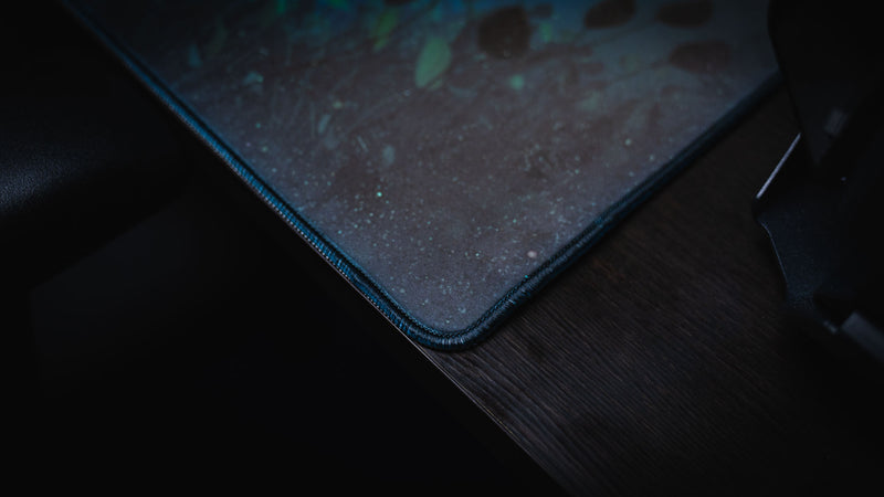 Close-up of the Official Rust Labs Breach deskmat highlighting the premium stitched edge, durable fabric surface, and underwater ocean floor artwork inspired by Rust's Labs monument.
