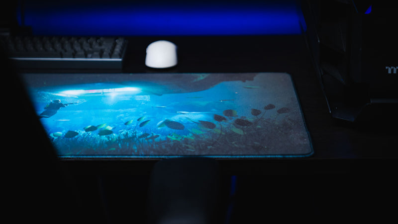 Official Rust Labs Breach deskmat featuring a detailed underwater Rust Labs scene with marine life, stitched edges, and a premium gaming desk setup.
