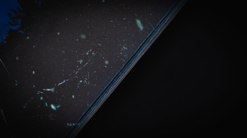 Close-up detail of the Official Rust Twilight Roam deskmat highlighting the premium stitched edge and smooth gaming surface.
