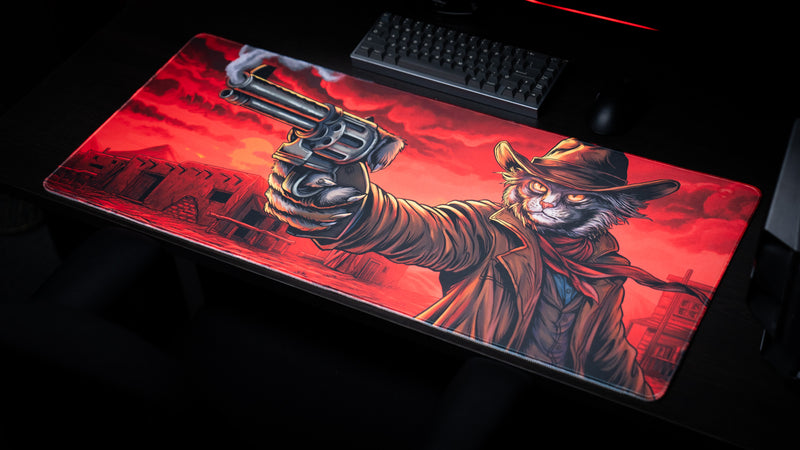 Only PVP Cat gaming deskmat viewed from above at an angle, displaying the frontier town and feline gunslinger beside a keyboard.