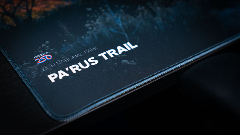 Close-up of the Parus Trail deskmat featuring the Zion National Park title, America 250 logo, premium stitched edges, and detailed landscape photography.
