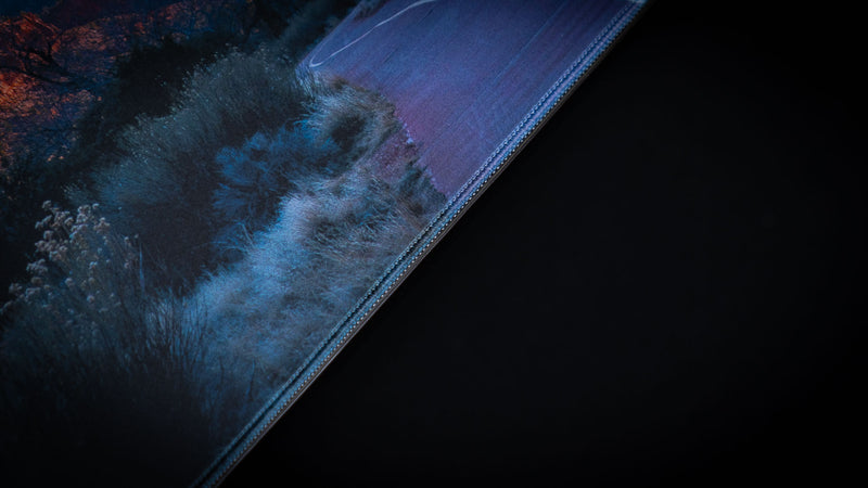 Close-up of the Parus Trail deskmat highlighting the premium stitched edge, detailed desert vegetation, paved trail, and high-resolution Zion National Park photography.