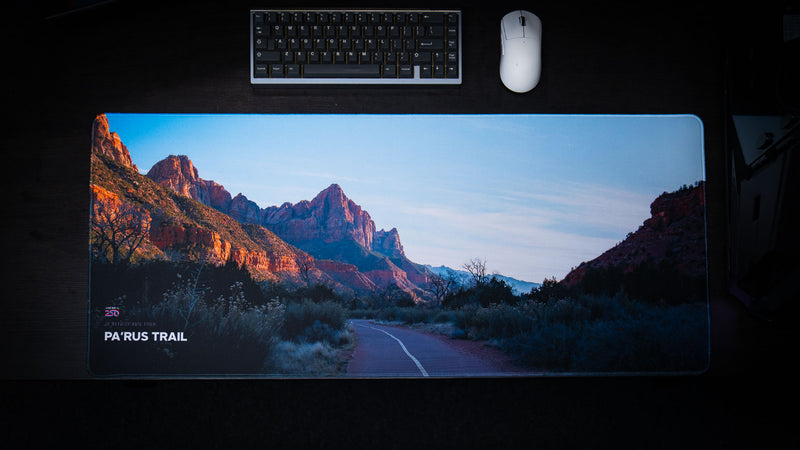 Parus Trail deskmat featuring the iconic paved trail leading through the towering sandstone cliffs of Zion National Park, displayed in a premium desktop setup.