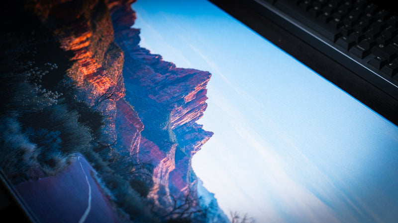 Parus Trail deskmat displayed on a desktop gaming setup, featuring the scenic paved trail winding through the towering sandstone cliffs of Zion National Park.