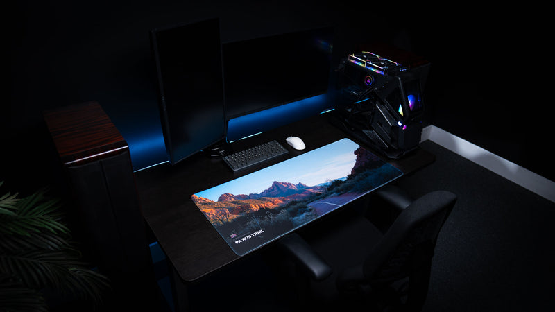Parus Trail deskmat showcased in a premium gaming workstation, featuring the scenic hiking trail and dramatic sandstone cliffs of Zion National Park.
