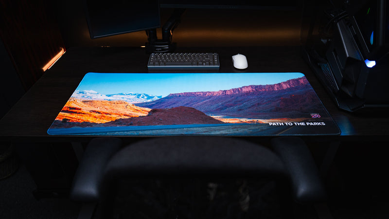 Front view of the Path to the Parks America 250 deskmat featuring a colorful Utah desert landscape with red rock cliffs, snowy mountains, and road artwork.