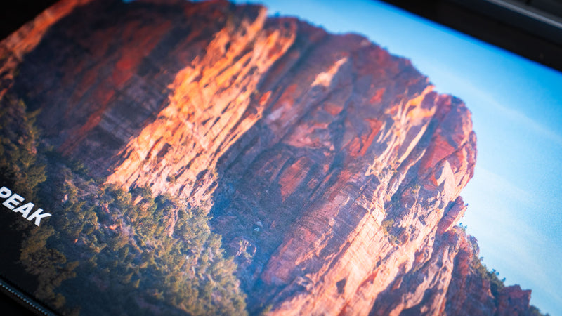 Close-up of the Patriarch Peak deskmat showcasing Zion National Park's towering sandstone cliffs with vibrant HD print, premium stitched edges, and a smooth gaming surface.