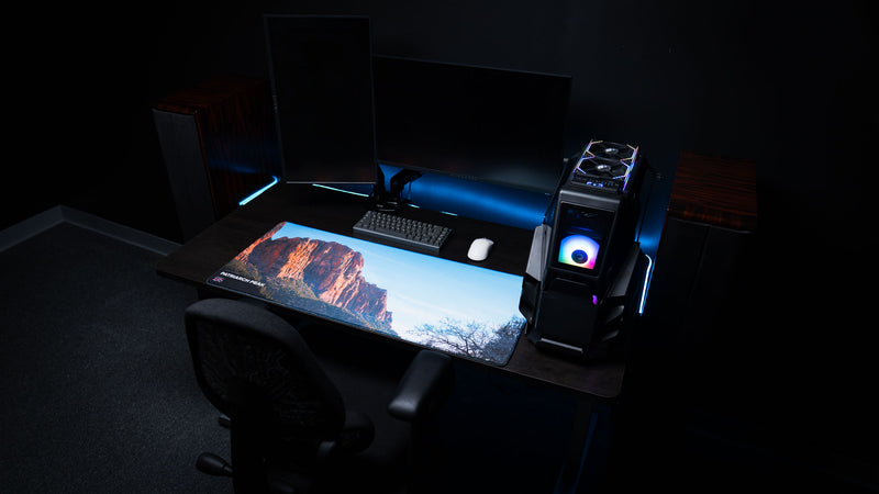 Patriarch Peak deskmat displayed in a premium gaming workstation, featuring Zion National Park's towering sandstone cliffs, vibrant HD photography, and premium stitched edges.