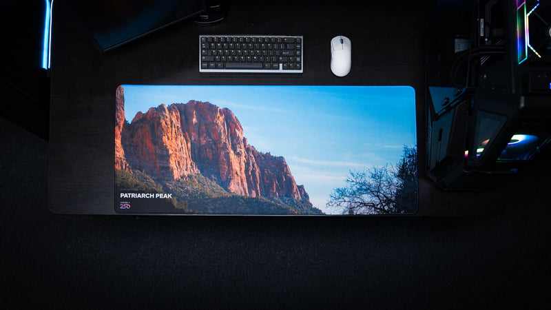 op-down view of the Patriarch Peak deskmat featuring Zion National Park's towering sandstone cliffs, vibrant HD photography, premium stitched edges, and a spacious gaming surface.