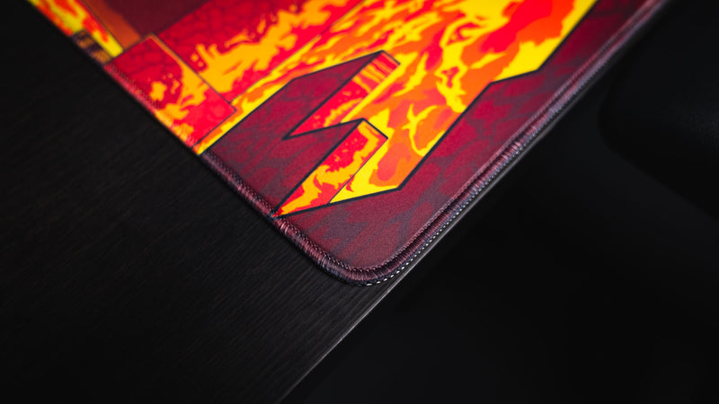 Close-up of the stitched corner and lava artwork on the PhoenixSC Phoenix Chan deskmat