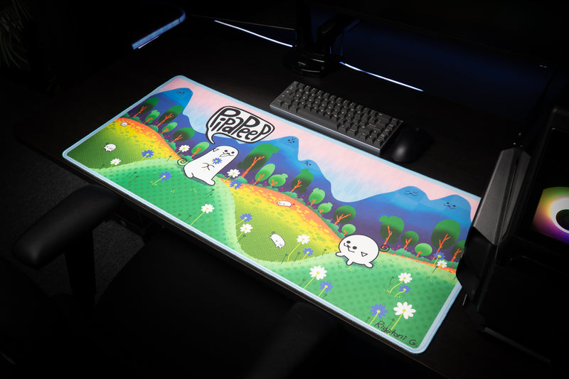 Opposite angled view of Pippa Peep's Pipaland deskmat with cartoon characters, flowers, and blue mountains.
