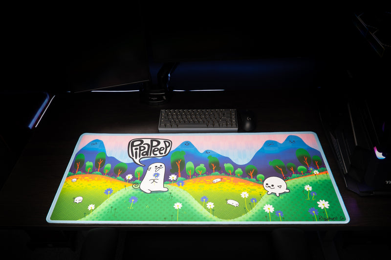 Front view of Pippa Peep's Pipaland deskmat on a dark gaming desk beneath a keyboard and mouse.