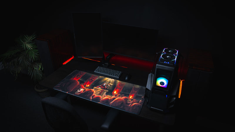 Pravus Crimson Convocation deskmat displayed in a complete gaming battlestation with dual monitors, RGB gaming PC, mechanical keyboard, and dark red ambient lighting.