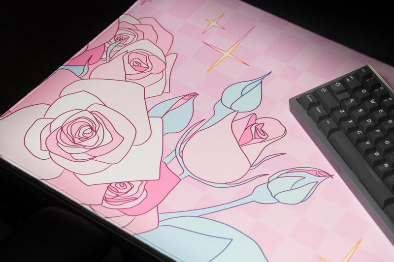 Close-up of pink rose artwork, blue-green leaves, and gold accents on the Full Bloom desk mat.