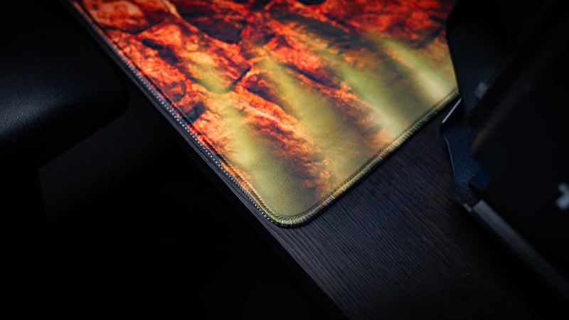 Close-up of The Doorcamper / Angle 3 Rust deskmat highlighting premium stitched edges, durable cloth construction, and detailed stone wall artwork on a high-performance gaming desk mat.