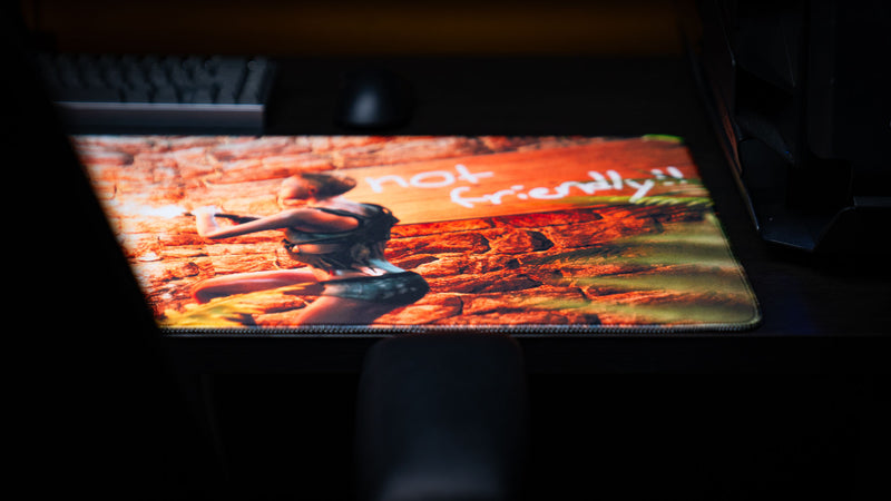 Right-side close-up of The Doorcamper / Angle 3 Rust deskmat showcasing the "Not Friendly!!" sign, detailed artwork, stitched edges, and premium extended gaming mouse pad surface.
