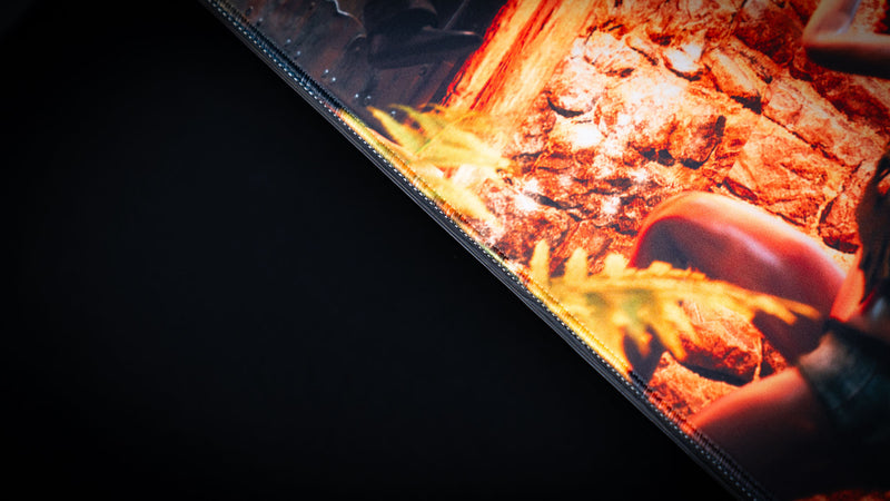 Close-up of The Doorcamper / Angle 3 Rust deskmat showcasing premium stitched edges, vibrant stone base artwork, and a durable cloth surface built for high-performance gaming.