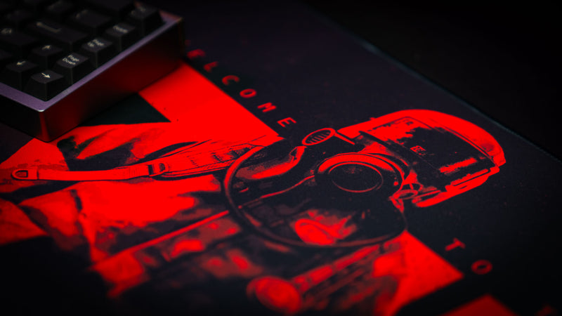 Close-up detail of the Welcome to Rust deskmat featuring glowing red hazmat character artwork and cinematic gaming aesthetics.