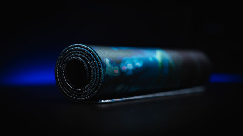 Official Rust Hunted XXL deskmat rolled for storage, showcasing the premium stitched-edge cloth surface and durable flexible construction.