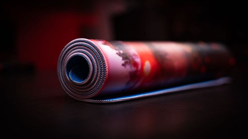 Macro close-up of the rolled Rust “Minicopter Joyride” deskmat highlighting stitched edges, premium fabric texture, and rubber base.