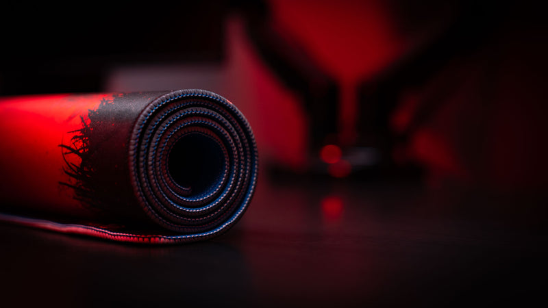 Rolled Rust Nighttime Patrol deskmat showcasing premium stitched edges and a striking red-and-black tactical survivor design inspired by nighttime reconnaissance missions.