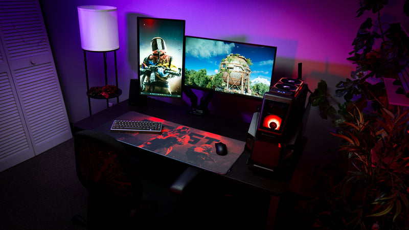 Rust Scientist Trio deskmat featured in a complete gaming battlestation with dual monitors, custom PC, RGB lighting, mechanical keyboard, and mouse.