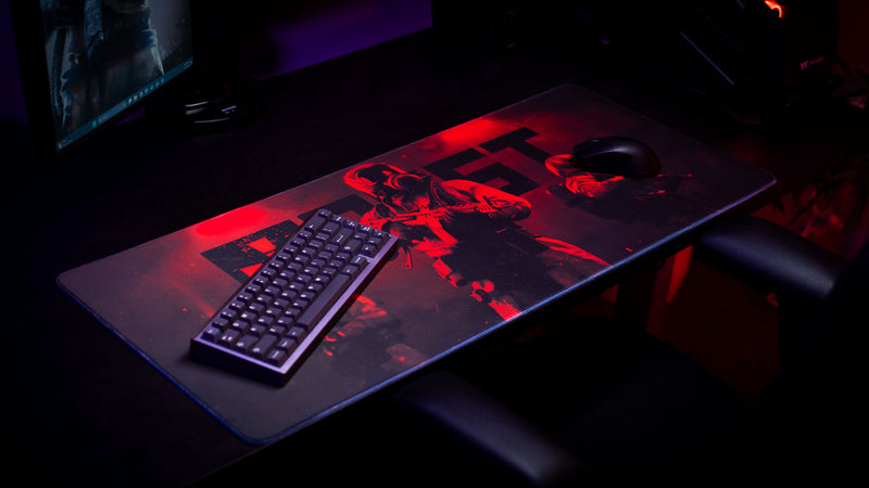 Rust Scientist Trio deskmat displayed in a gaming setup with mechanical keyboard and mouse, showcasing the full artwork and extended desk coverage.