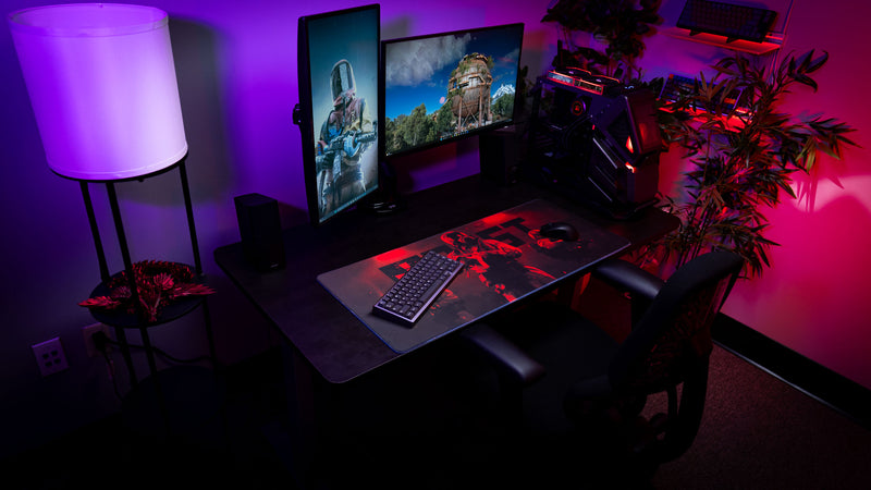 Rust Scientist Trio deskmat showcased in an immersive RGB gaming setup with dual monitors, custom PC, and dramatic red and purple ambient lighting.