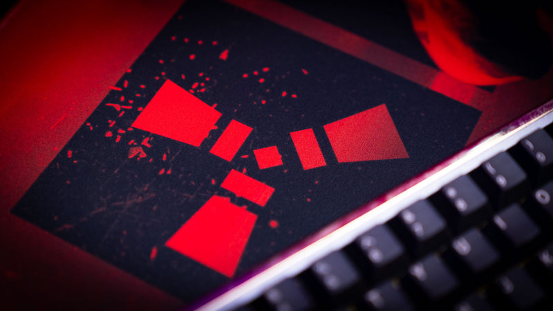 Close-up of the Rust logo featured on the Scientist Trio deskmat, highlighting premium print quality, vivid red lighting, and detailed gaming artwork.
