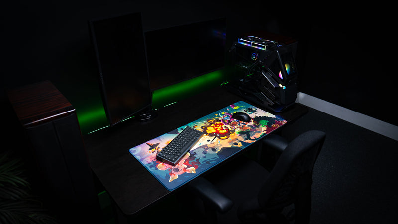 Sedi-mat deskmat by Pokedex Studios displayed in a gaming setup with keyboard and mouse, showcasing vibrant fantasy creature artwork, stitched edges, and premium print quality.