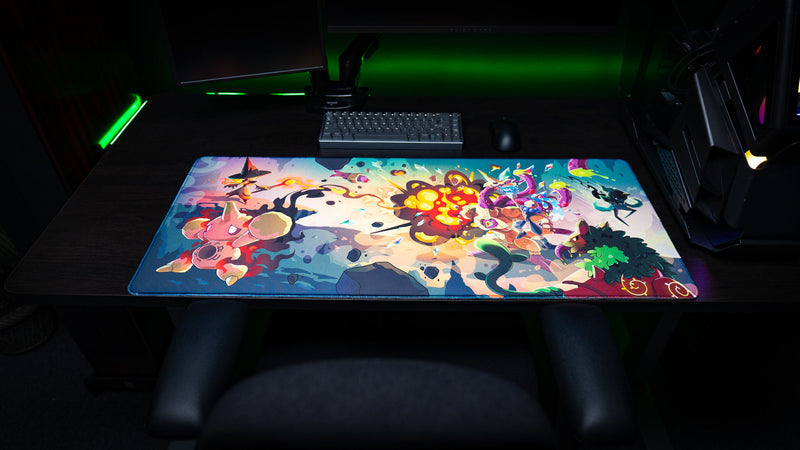 Front view of the Sedi-mat deskmat by Pokedex Studios on a gaming desk, featuring vibrant fantasy creature artwork, explosive spell effects, stitched edges, and premium print quality.