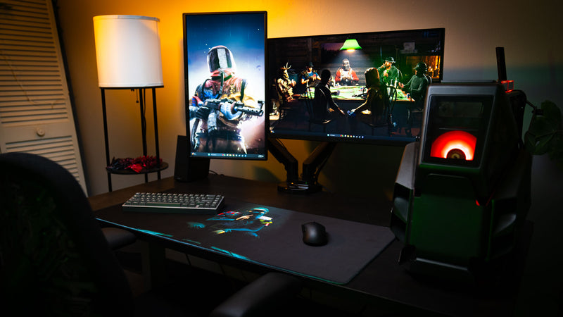 Shh Rust deskmat displayed in a gaming setup, featuring a spotlight-lit welding mask figure making a silence gesture against a dark minimalist background
