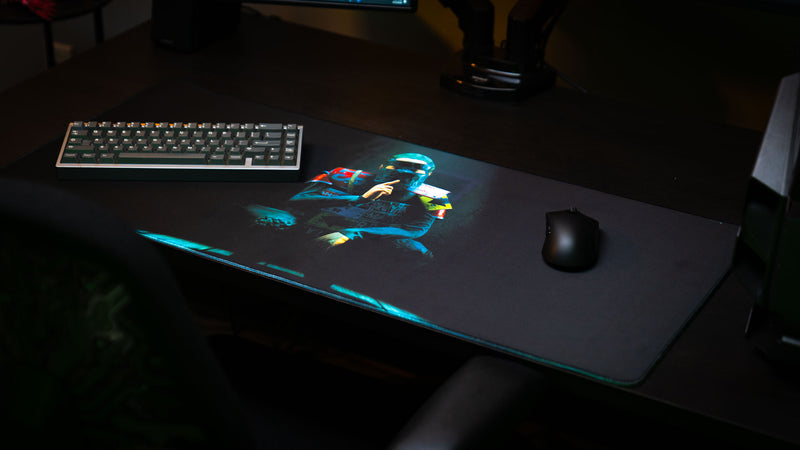 The Shh Rust deskmat displayed with a mechanical keyboard and gaming mouse, highlighting the dark atmospheric artwork and premium extended deskmat design.