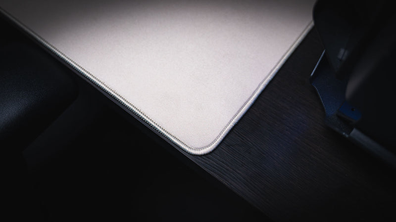 Close-up of a rounded corner and stitched edge on the Feathered Host deskmat
