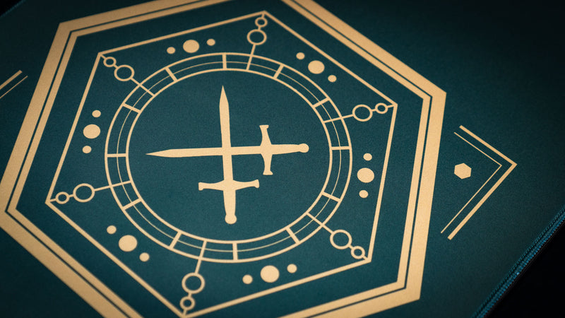 Close-up of gold crossed swords inside the geometric sigil on House Veridian deskmat