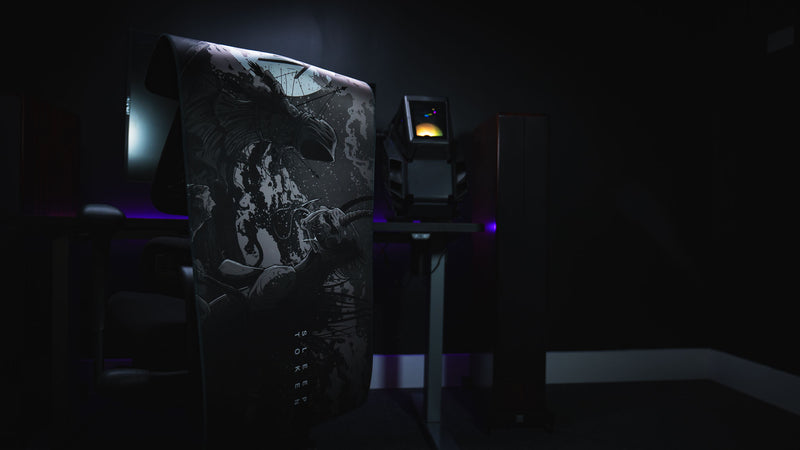 The Battle Sleep Token deskmat draped over a chair in a dark gaming setup