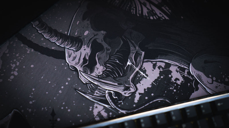 Close-up of the horned creature illustration on The Battle Sleep Token deskmat beside a keyboard