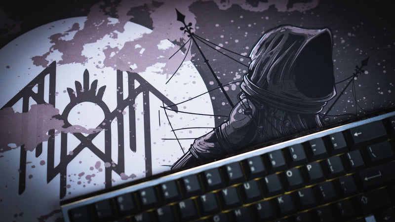 Close-up of the moon sigil and hooded figure on The Battle Sleep Token deskmat beside a keyboard